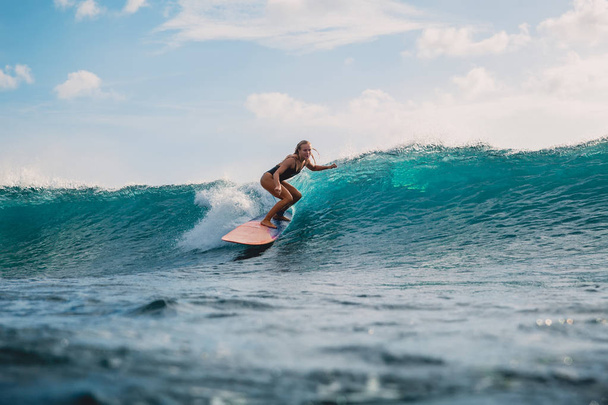 Surfista profesional en tabla de surf. Mujer en el océano durante el surf. Surfista y ola oceánica
 - Foto, Imagen