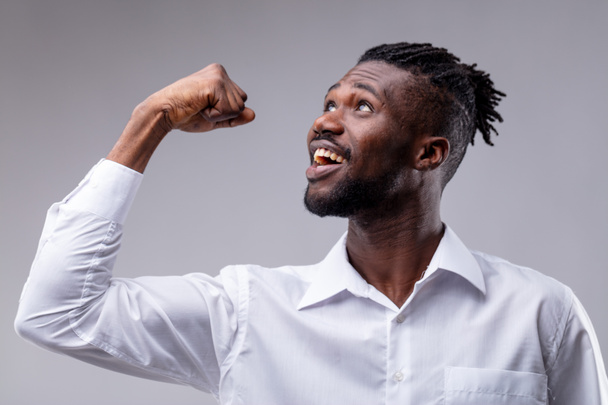 zwarte man jubelend en blijdschap vanwege sommige goed nieuws als hij won een prijs of een werk-succes - Foto, afbeelding