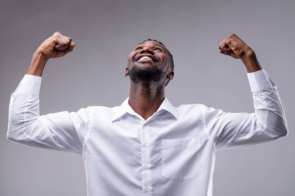 czarny człowiek, radując i radość ze względu na dobre wieści, jak zdobył nagrodę lub powodzenie pracy - Zdjęcie, obraz