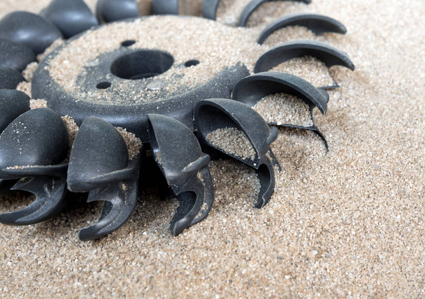 Стара водяна турбіна на сухому піску з водою, непотрібна в посушливому стані
 - Фото, зображення