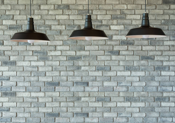 La lámpara de tres contra un fondo de pared de ladrillo decorativo en el hogar. - se puede utilizar para mostrar sus productos
. - Foto, Imagen