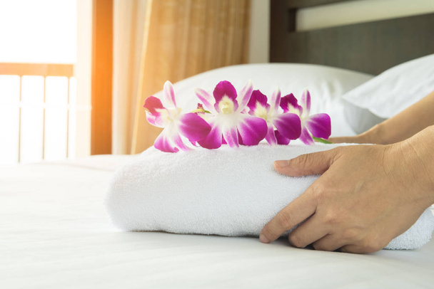 Naiset panivat valkoisen pyyhkeen sängylle. Sisäkkö palvelu siivous hotellihuone käsite
. - Valokuva, kuva