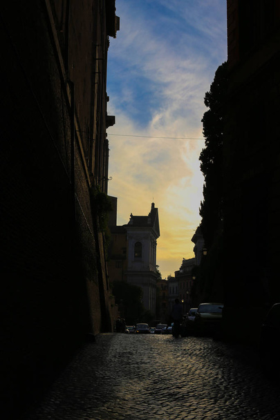 Сутінкова вузька вулиця з бульбашками в хмарах заходу сонця
. - Фото, зображення