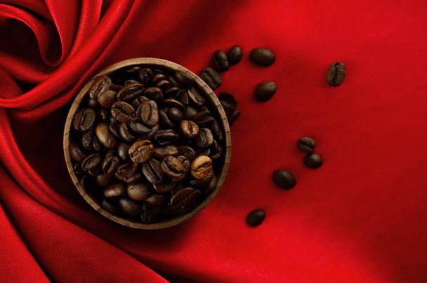 Fond abstrait de luxe en soie, morceau de tissu, texture de tissu rouge profond avec des grains de café arôme dessus
 - Photo, image