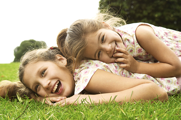 Dos hermanas riendo y jugando en el parque
 - Foto, imagen