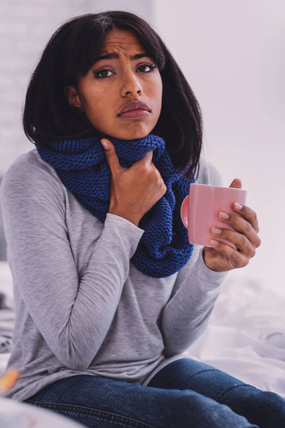 Sick female person covering her neck with scarf - Zdjęcie, obraz