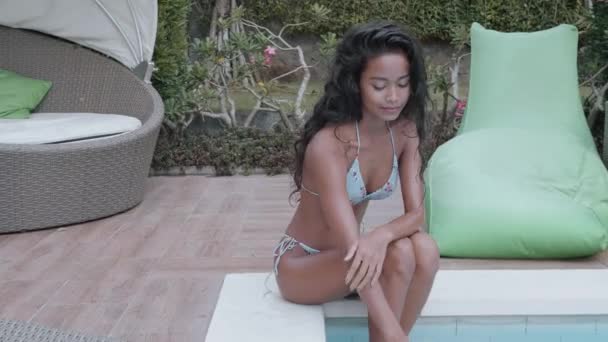 schöne sexy Dame im Bikini entspannen in der Nähe des Swimmingpools. Porträt eines Modelmädchens im Freien. Schönheit Frau mit attraktivem Körper im Badeanzug - Filmmaterial, Video