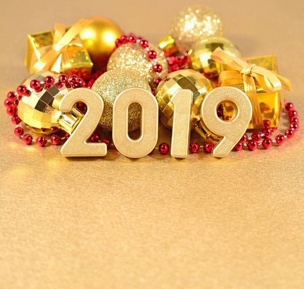 2019 Jahr goldene Figuren auf dem Hintergrund der goldenen und roten Weihnachtsdekoration - Foto, Bild