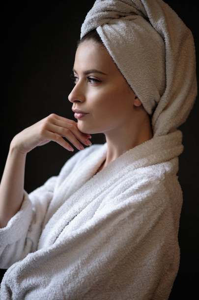Young woman in a bathrobe and towel on her head, spa and care portrait, clean natural face - 写真・画像