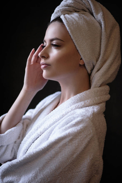 Jovem mulher de roupão de banho e toalha na cabeça, spa e retrato de cuidados, rosto natural limpo
 - Foto, Imagem
