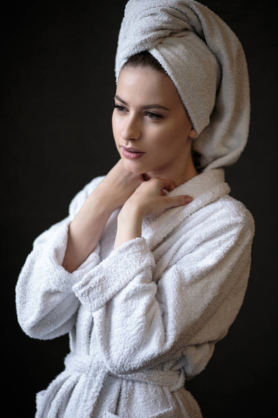 Young woman in a bathrobe and towel on her head, spa and care portrait, clean natural face - Fotografie, Obrázek