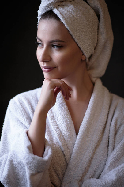 Young woman in a bathrobe and towel on her head, spa and care portrait, clean natural face - Valokuva, kuva