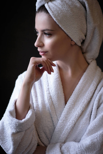 Young woman in a bathrobe and towel on her head, spa and care portrait, clean natural face - 写真・画像