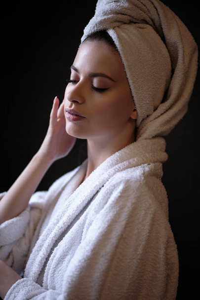 Young woman in a bathrobe and towel on her head, spa and care portrait, clean natural face - Foto, Imagen