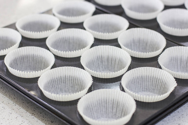 Empty paper forms for muffins and cupcakes in a metal tray - Foto, immagini