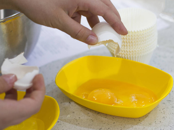 Hands break the raw egg. Separation of egg white from yolk - Photo, Image