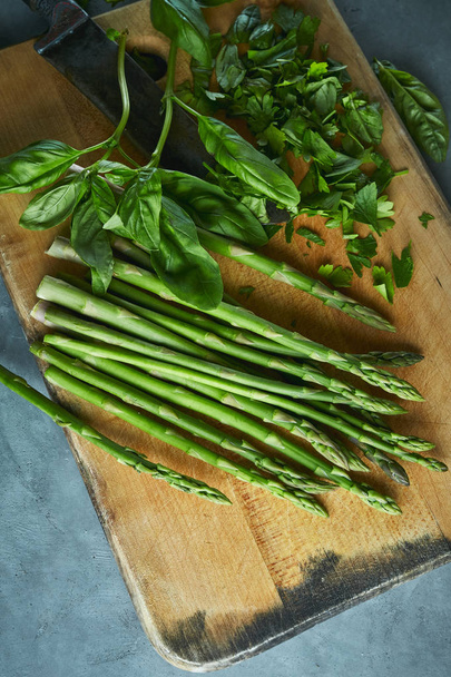 cutting board with asparagus, parsley and basil - Fotoğraf, Görsel
