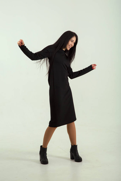 Beautiful woman in a black coat. Fashion and style. Dancing. - Фото, зображення