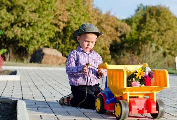 χαριτωμένο μικρό αγόρι με ένα φορτηγό παιχνίδι - Φωτογραφία, εικόνα