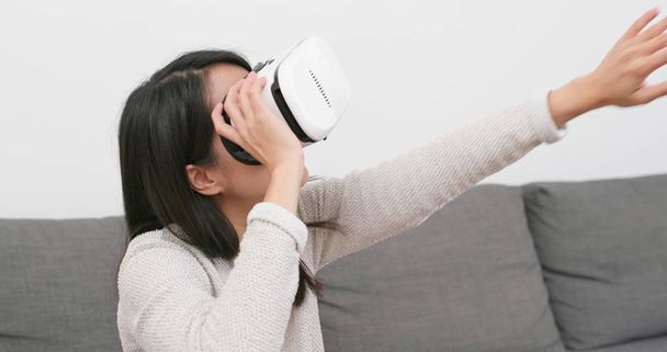 Femme regardant avec un appareil VR à la maison
 - Photo, image