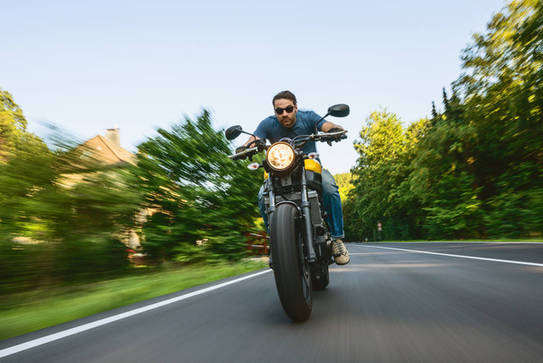 modern scrambler motorkerékpár az erdei úton lovaglás. szórakozás vezetni az üres út egy motorkerékpár túra utazás. copyspace az Ön egyedi szövegéhez. - Fotó, kép