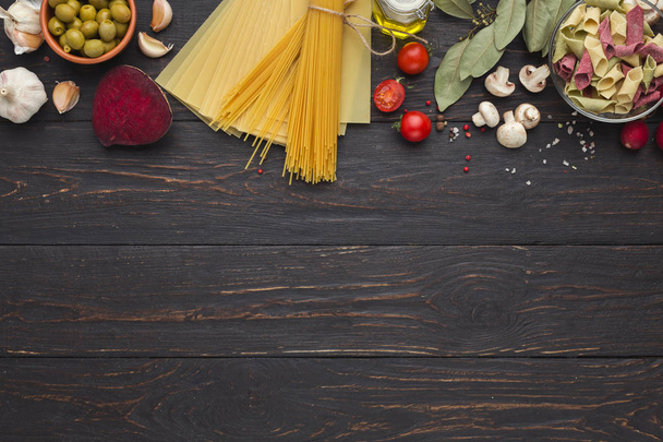 Dry mixed pasta on wooden background, top view - 写真・画像