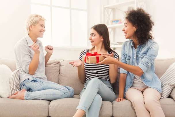 Excited woman getting gift from her friends - Photo, Image