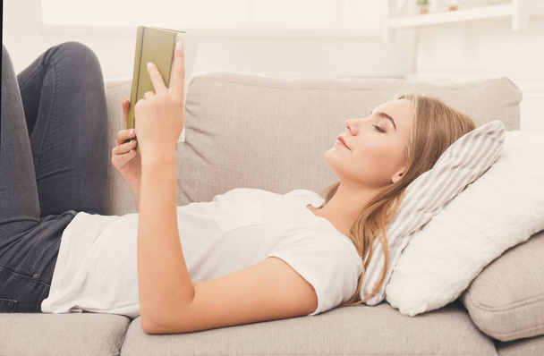 Cozy home. Young thoughtful woman with book - Foto, Imagen