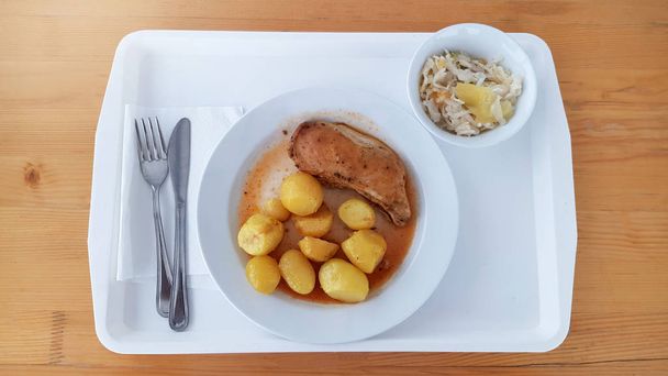 Κοντινό πλάνο του πρωινού του ξενοδοχείου πρωινό σε μπουφέ πρωινό γεύμα, ψητό στήθος κοτόπουλου, ψητές πατάτες με κόκκινη σάλτσα σε λευκό πιάτο και φρέσκια σαλάτα λαχανικών σε λευκό μπολ. - Φωτογραφία, εικόνα
