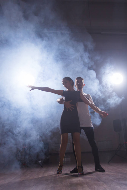 Jeune couple dansant danse latine Bachata, merengue, salsa. Deux poses d'élégance en cours de danse
 - Photo, image