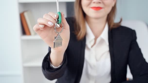 Sorridente giovane donna agente immobiliare consegna le chiavi di nuovi immobili
 - Filmati, video