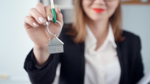 Sonriente joven agente inmobiliario entrega las llaves de los nuevos bienes raíces
 - Imágenes, Vídeo