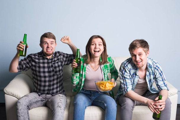 Happy friends or football fans watching soccer on tv and celebrating victory. Friendship, sports and entertainment concept - 写真・画像