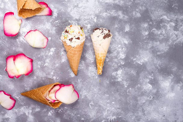 Состав вафель-мороженое с лепестками роз на каменном фоне с копировальным пространством, плоская укладка
 - Фото, изображение