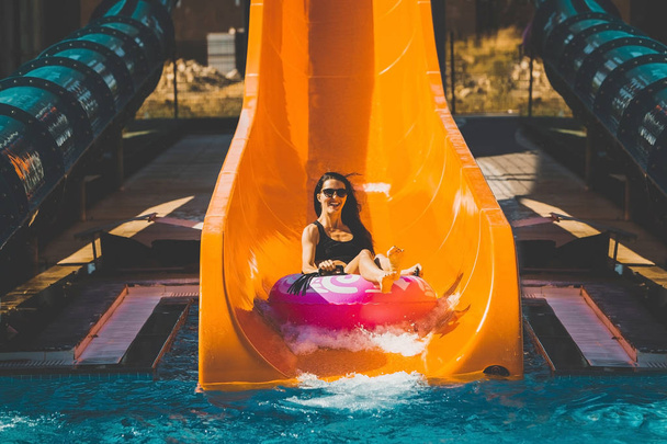 girl going down by the slide in aqua park - Photo, Image