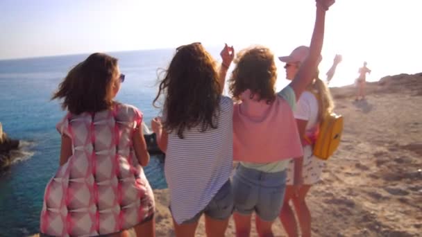 Mujeres felices bailando en la orilla del mar. Vista posterior de chicas alegres divirtiéndose
 - Metraje, vídeo