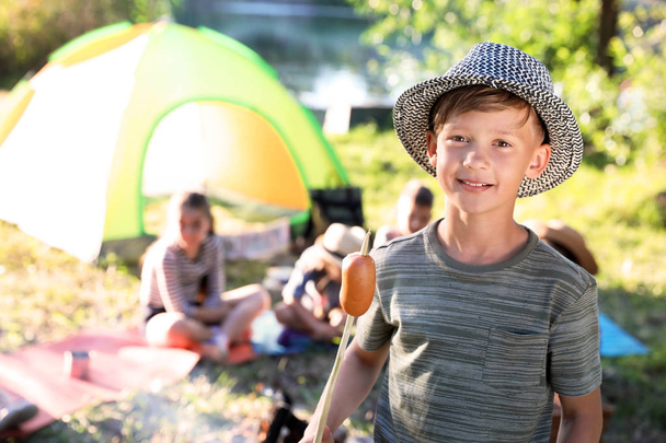 Little boy with fried sausage outdoors. Summer camp - Φωτογραφία, εικόνα