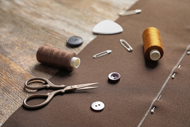 Set of tailoring accessories and fabric on wooden background - Photo, Image