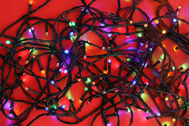 Glowing Christmas lights on color background, top view - Fotó, kép