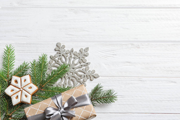 Flat lay composition with Christmas gift and fir branches on wooden background - Foto, Imagen
