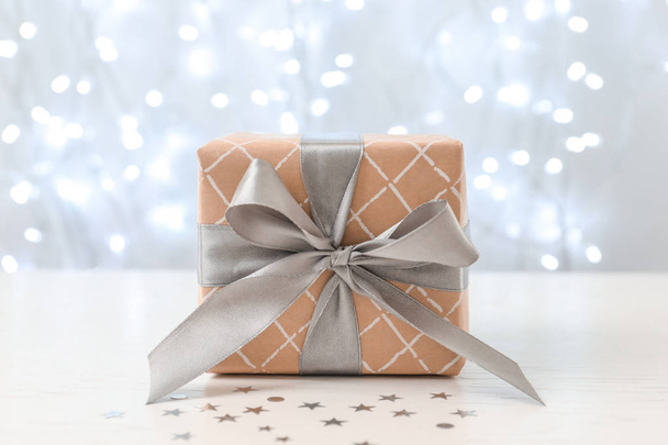 Christmas gift on table against blurred background - Foto, Bild