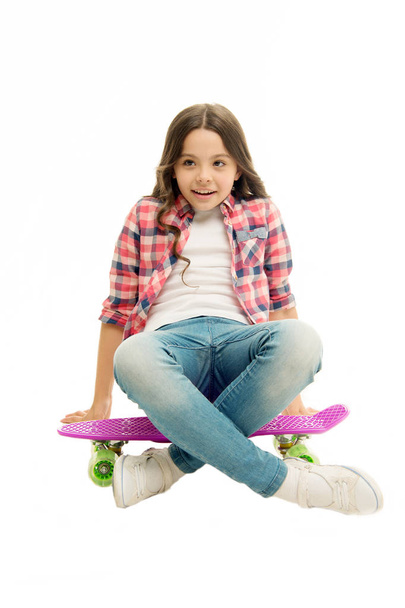 Sit and relax. Kid girl relaxed sits penny board. Learning how to ride penny board. Modern teen hobby. Girl happy face sit on penny board white background. Originally designed as girls skateboard - Photo, image