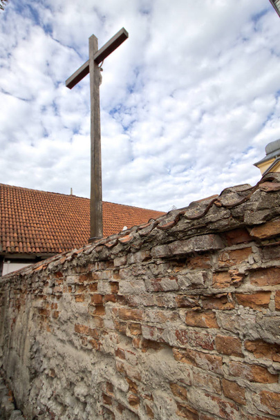 Krzyż w kościele obok ceglanego muru - Zdjęcie, obraz