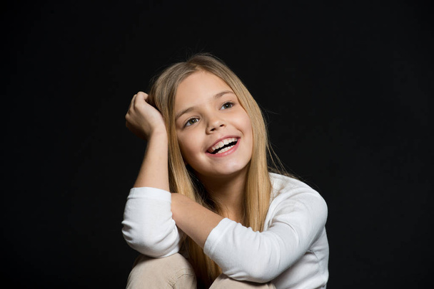 Dreamy mood. Girl long hair cute smiling dreamy face relaxing, black background. I wish all my dreams come true. Child happy carefree dreaming about future. Dreams come true - Foto, Imagem