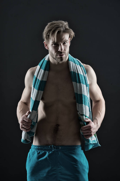 Sexy sportsman with muscular chest and belly. Man with towel on neck after training. Fitness athlete with fit torso in shorts. Sport and wellness. Hygiene, health and bodycare concept, vintage filter - Foto, afbeelding