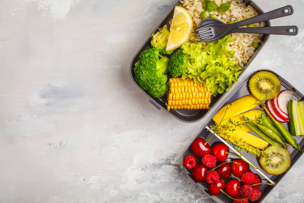 Healthy meal prep containers with brown rice, broccoli, vegetables, fruits and berries overhead shot with copy space, white background, top view - Foto, Imagem