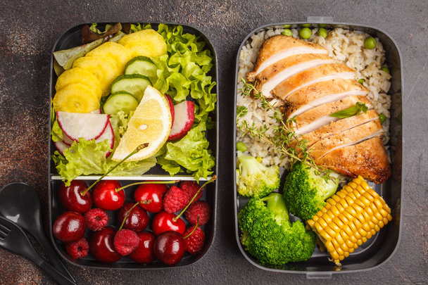 Healthy meal prep containers with grilled chicken with fruits, berries, rice and vegetables. Takeaway food jn dark background, top view - Fotoğraf, Görsel
