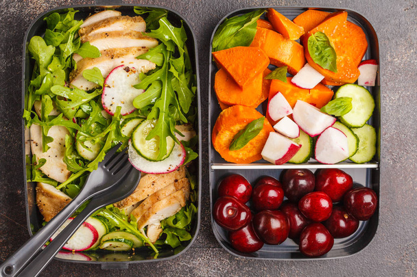 Healthy meal prep containers with grilled chicken with salad, sweet potato, berries, fruits and vegetables. Takeaway food. - 写真・画像