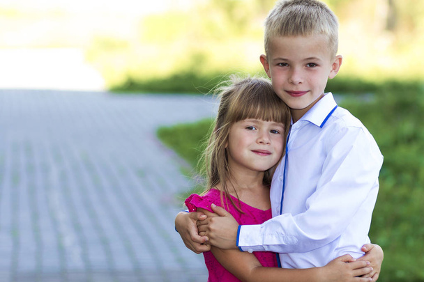Muotokuva lasten poika ja tyttö syleilee yhdessä. Rakkaus, hoito ja perhesuhteet
 - Valokuva, kuva