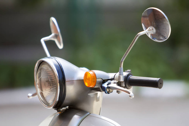 Close-up detail of new white shiny motorbike with round headlight, two mirrors and manual brake. Comfortable city and off road transportation, fuel economy, traveling and speed concept. - Φωτογραφία, εικόνα